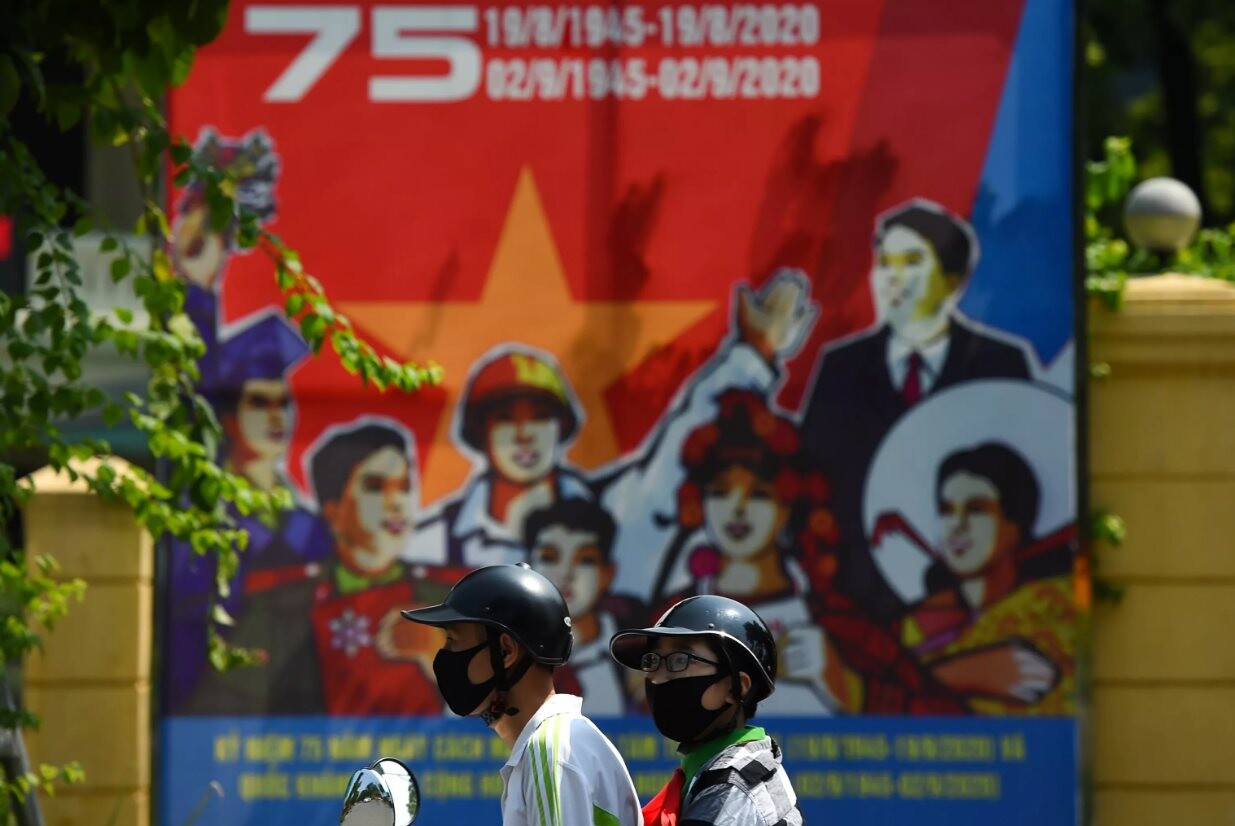 Người đi xe máy trên nền áp phích  mừng ngày Quốc khánh Việt Nam